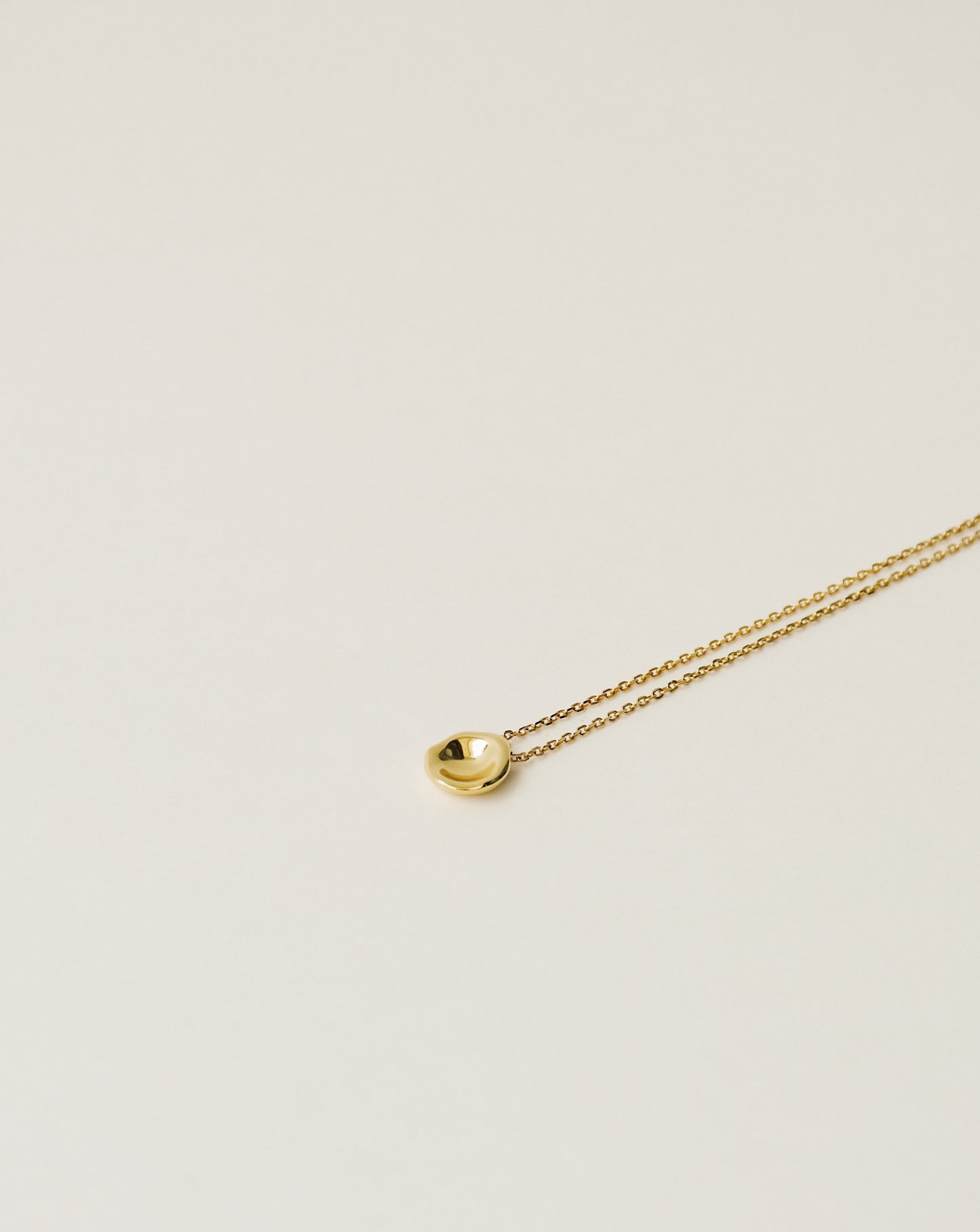 irregularly shaped tiny pendant necklace handcrafted from 925 sterling silver plated in 18k gold. 2020 slow fashion trend.