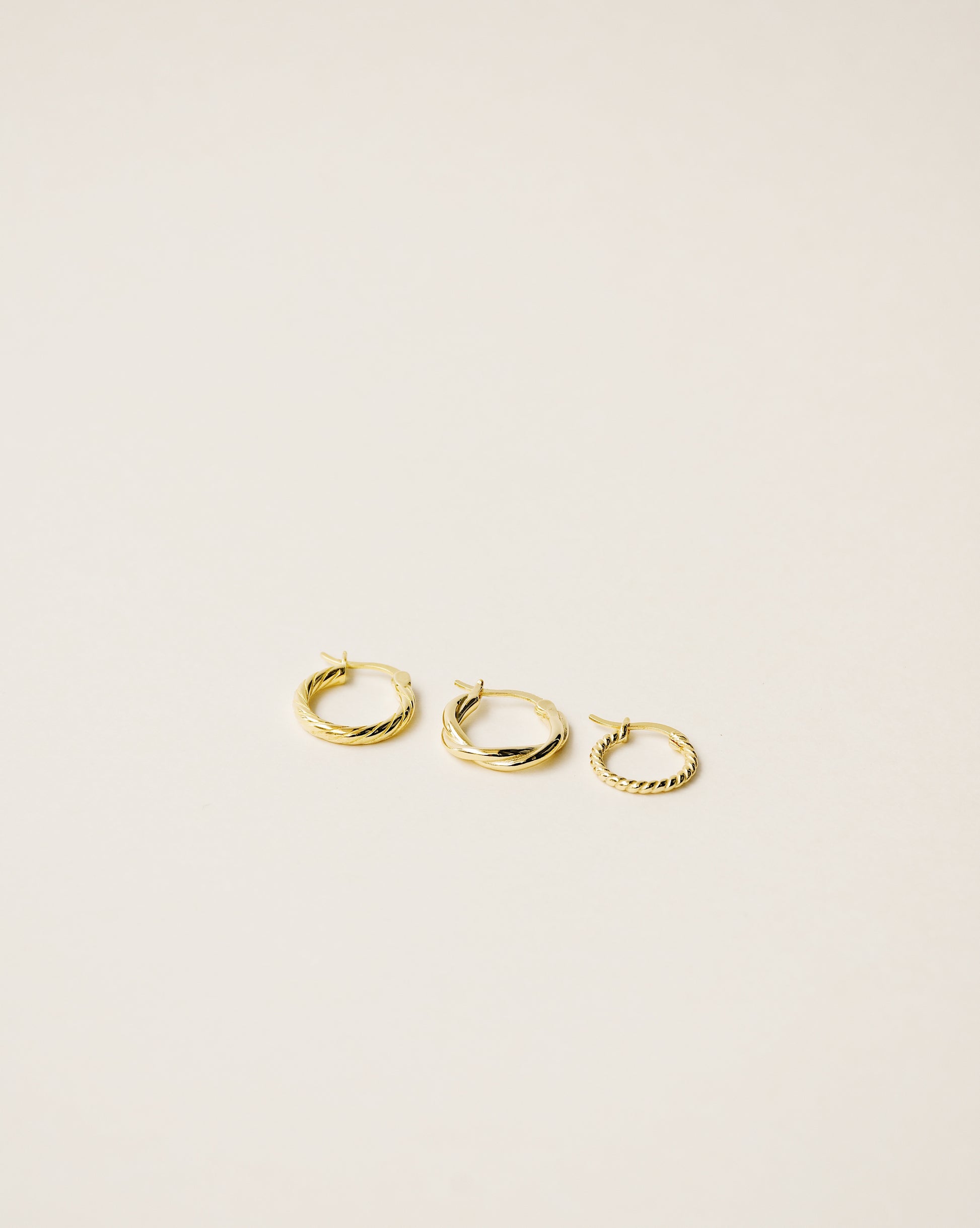 set of three different twisted hoop earrings handcrafted in 925 sterling silver plated in 18k gold. 2020 slow fashion trend.