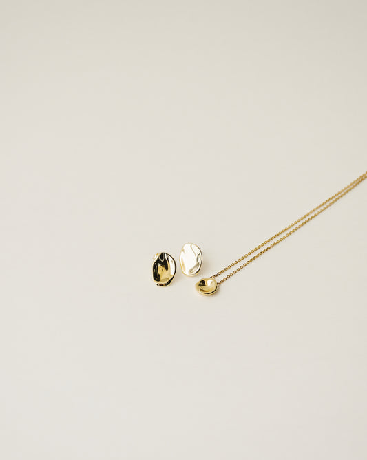 irregularly shaped tiny pendant necklace and stud earrings handcrafted from 925 sterling silver plated in 18k gold. 2020 slow fashion trend.