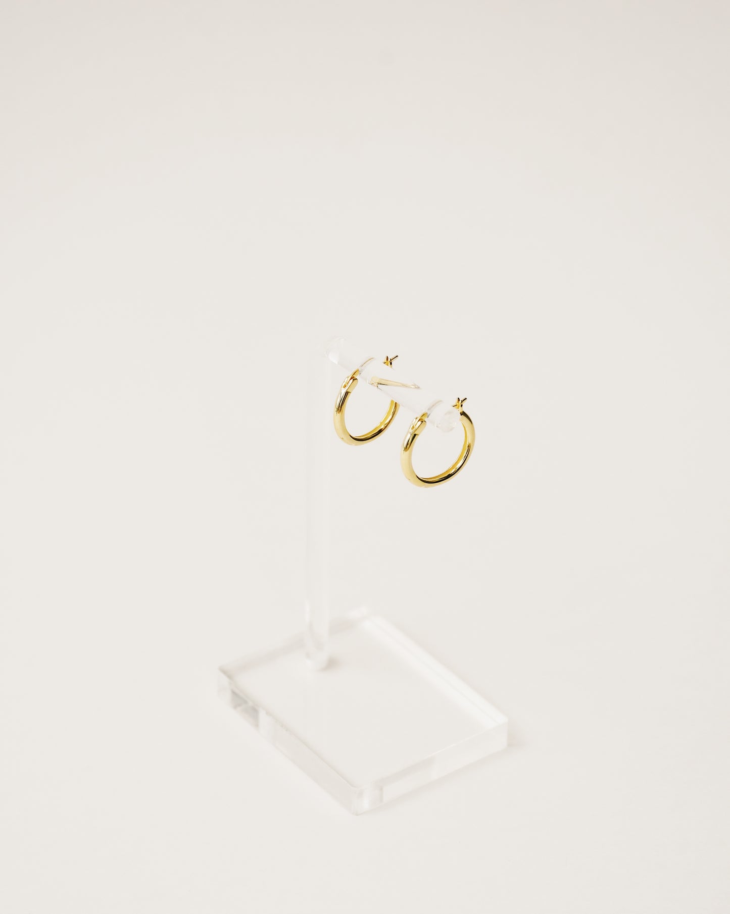 Basic shapes. minimalist and timeless mini hoop earrings handcrafted from 925 sterling silver plated in 18k gold. 2020 slow fashion trend.