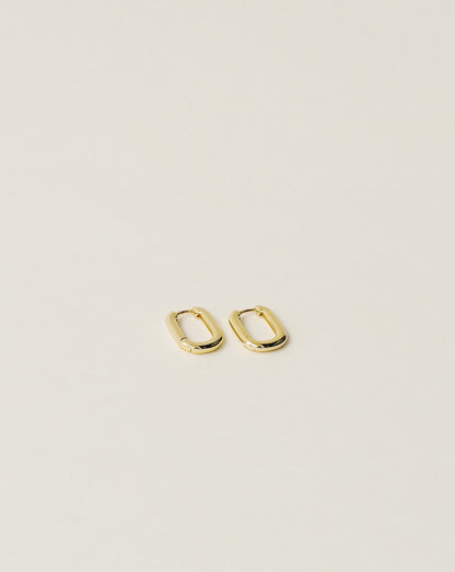 timeless and versatile oval shape huggie earrings handcrafted from 925 sterling silver plated in 18k gold. slow fashion trend 2020.
