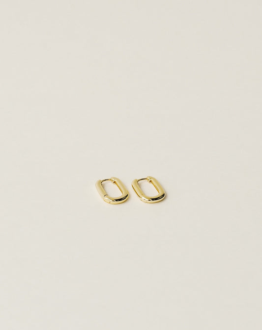 timeless and versatile oval shape huggie earrings handcrafted from 925 sterling silver plated in 18k gold. slow fashion trend 2020.