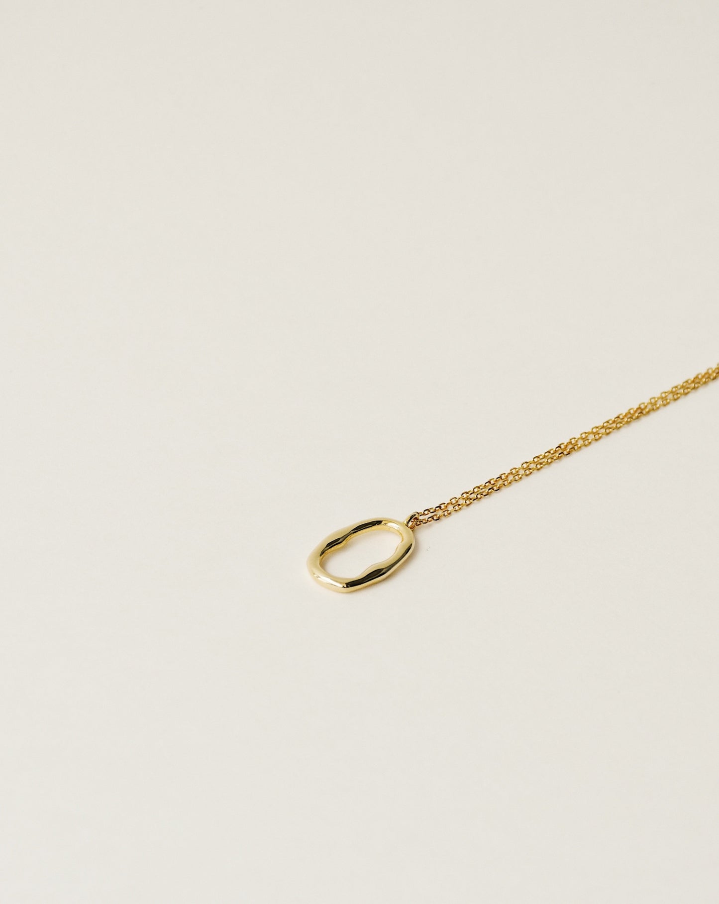 irregularly shaped minimalist pendant necklace handcrafted from 925 sterling silver plated in 18k gold. 2020 slow fashion trend.