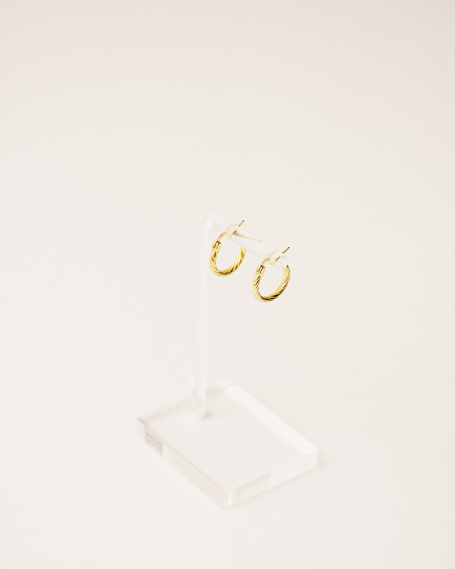 timeless and versatile twisted hoop earrings handcrafted from 925 sterling silver plated in 18k gold. 2020 slow fashion trend.