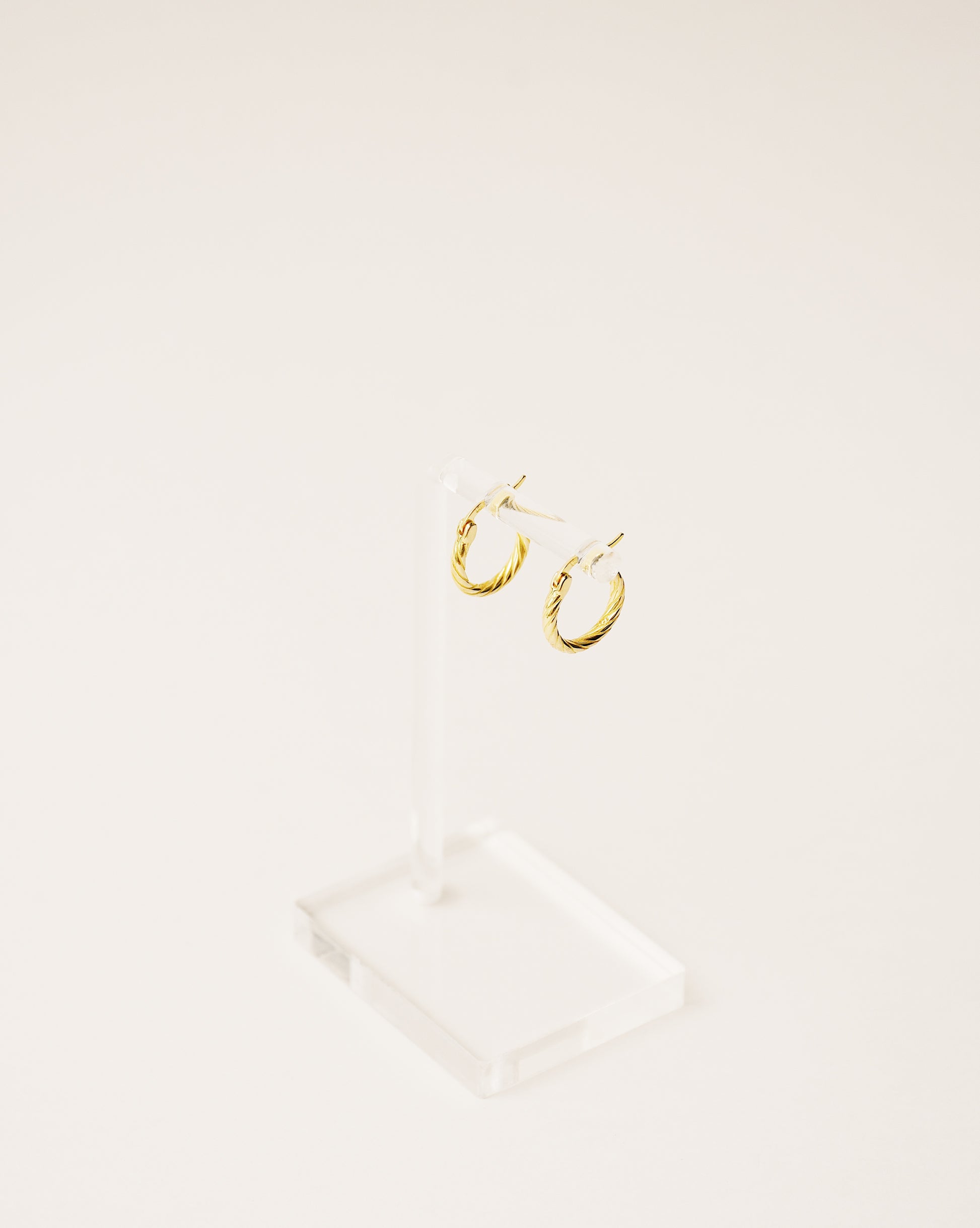 timeless and versatile twisted hoop earrings handcrafted from 925 sterling silver plated in 18k gold. 2020 slow fashion trend.