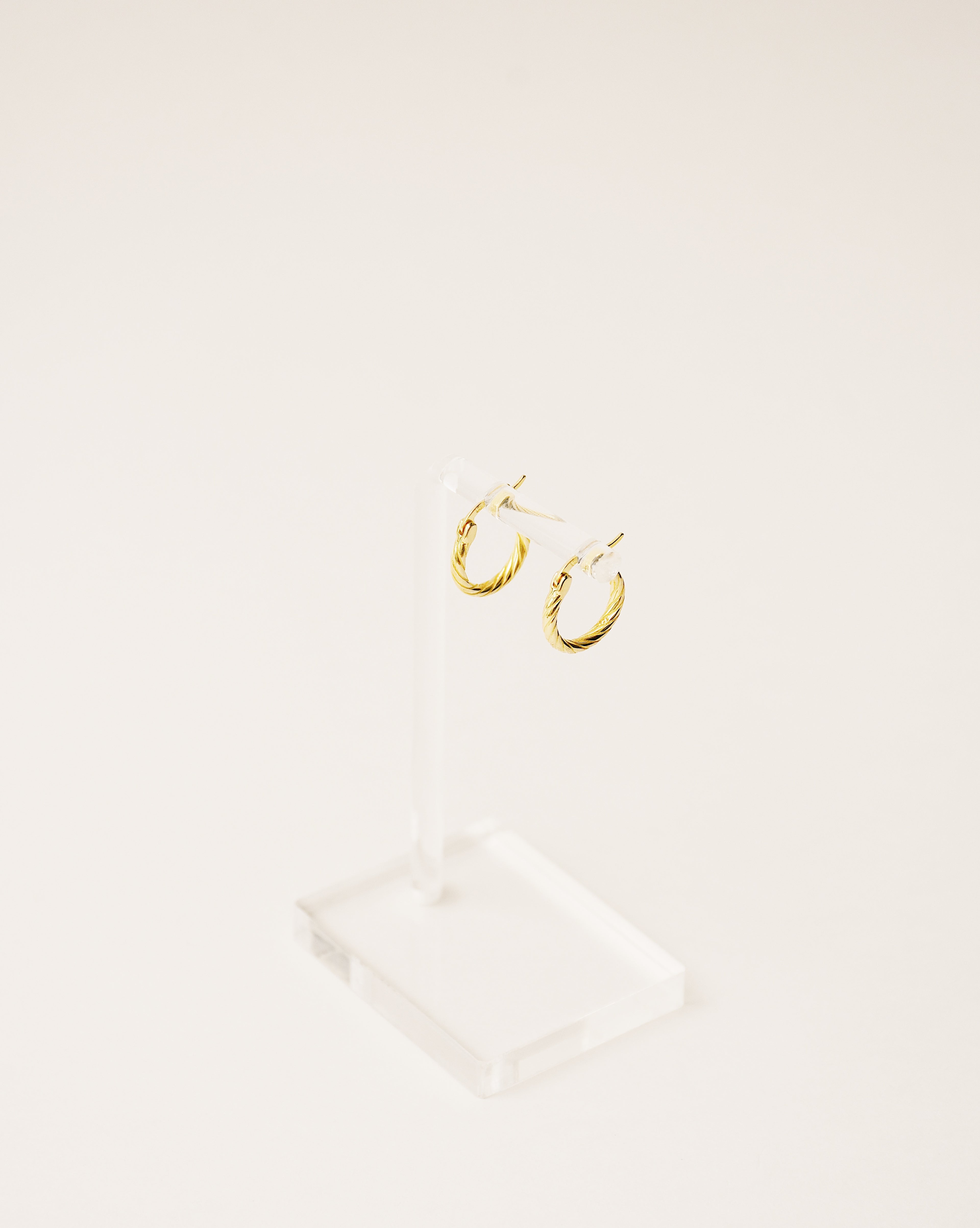 timeless and versatile twisted hoop earrings handcrafted from 925 sterling silver plated in 18k gold. 2020 slow fashion trend.