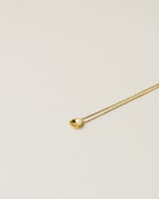 irregularly shaped tiny pendant necklace handcrafted from 925 sterling silver plated in 18k gold. 2020 slow fashion trend.