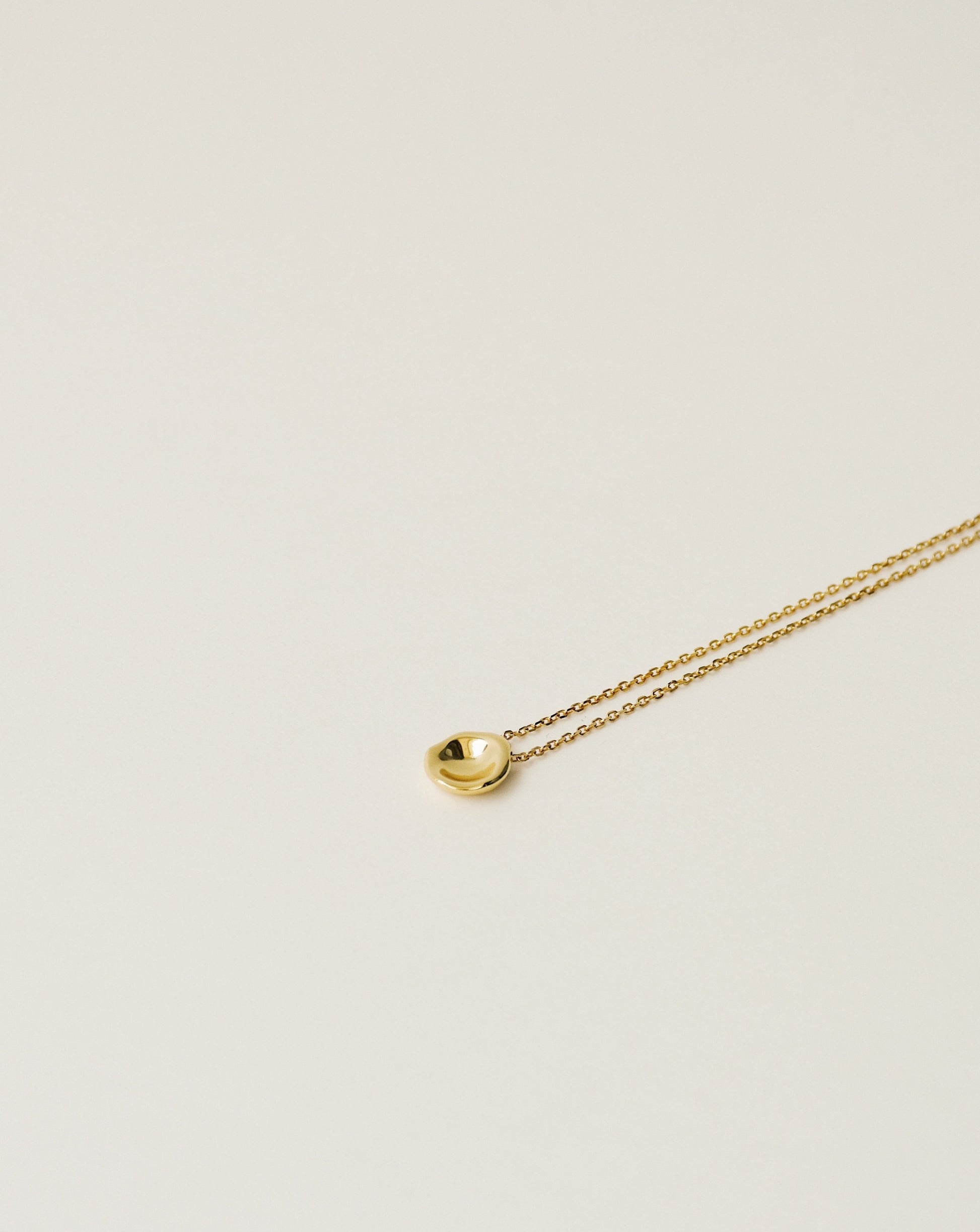 irregularly shaped tiny pendant necklace handcrafted from 925 sterling silver plated in 18k gold. 2020 slow fashion trend.