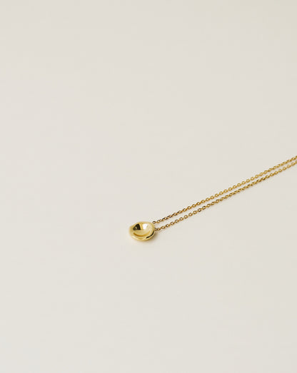 irregularly shaped tiny pendant necklace handcrafted from 925 sterling silver plated in 18k gold. 2020 slow fashion trend.