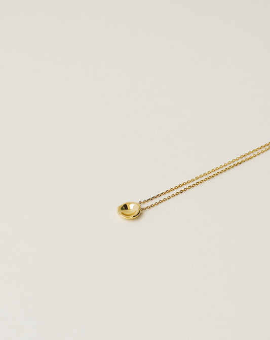 irregularly shaped tiny pendant necklace handcrafted from 925 sterling silver plated in 18k gold. 2020 slow fashion trend.