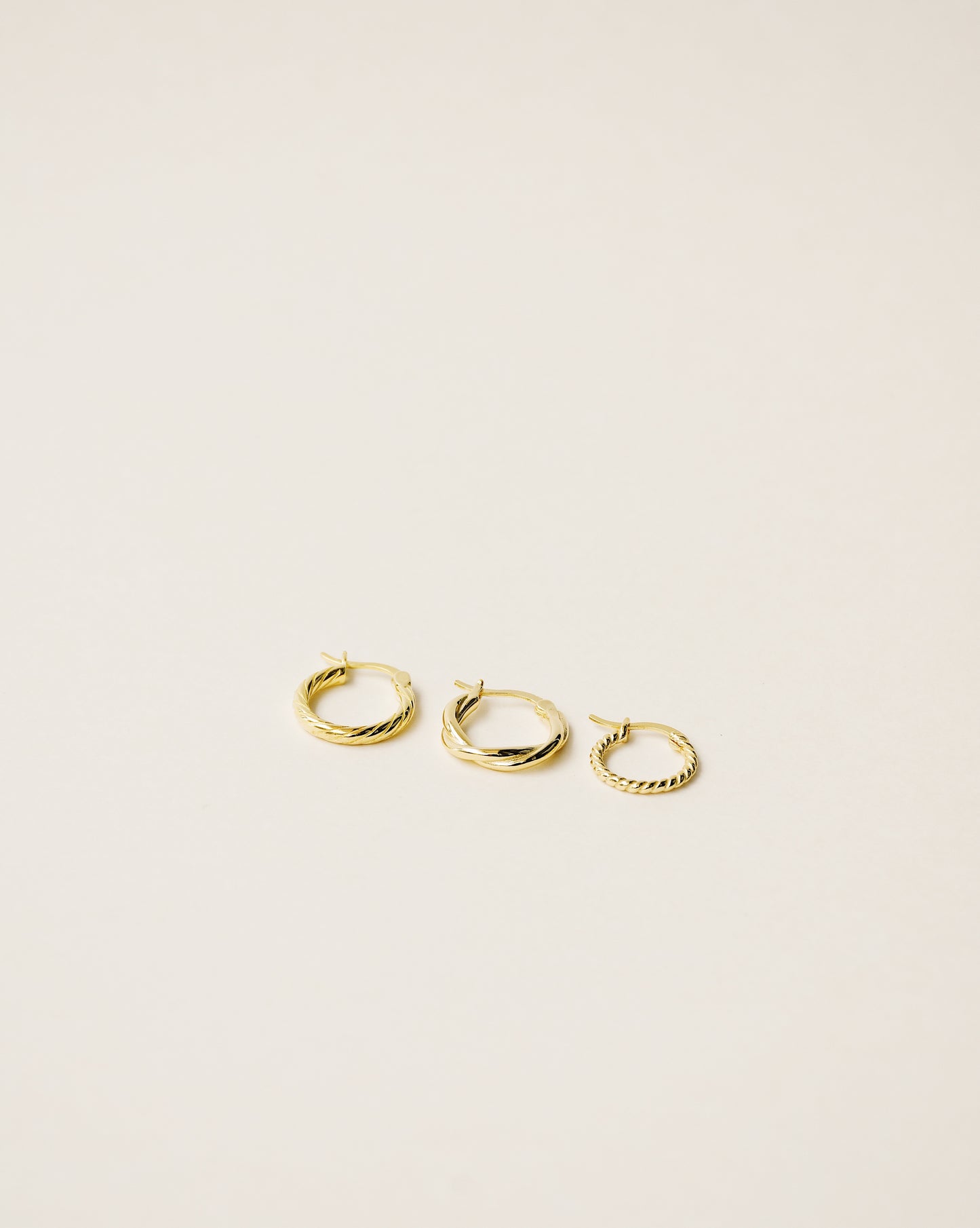 set of three different twisted hoop earrings handcrafted in 925 sterling silver plated in 18k gold. 2020 slow fashion trend.