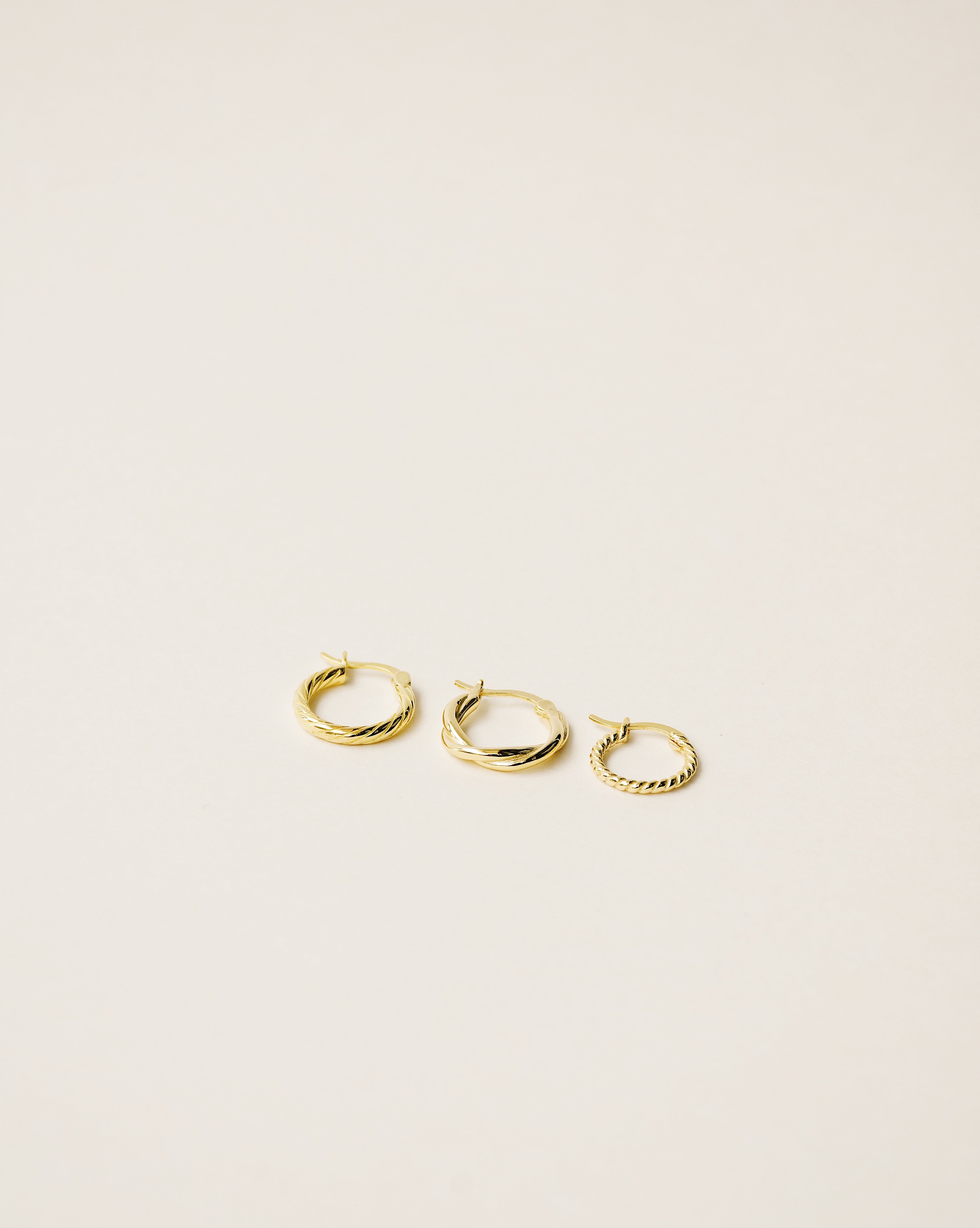 set of three different twisted hoop earrings handcrafted in 925 sterling silver plated in 18k gold. 2020 slow fashion trend.