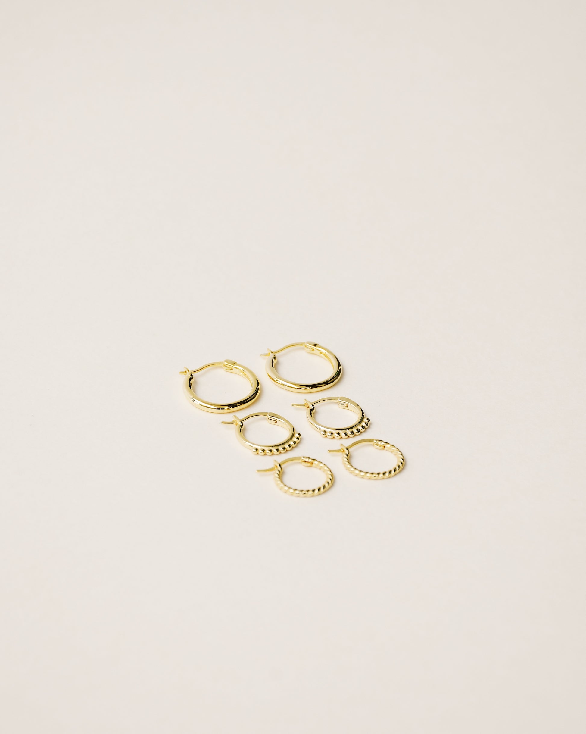 set of three stackable mini hoop earrings handcrafted from 925 sterling silver plated in 18k gold. 2020 slow fashion trend.