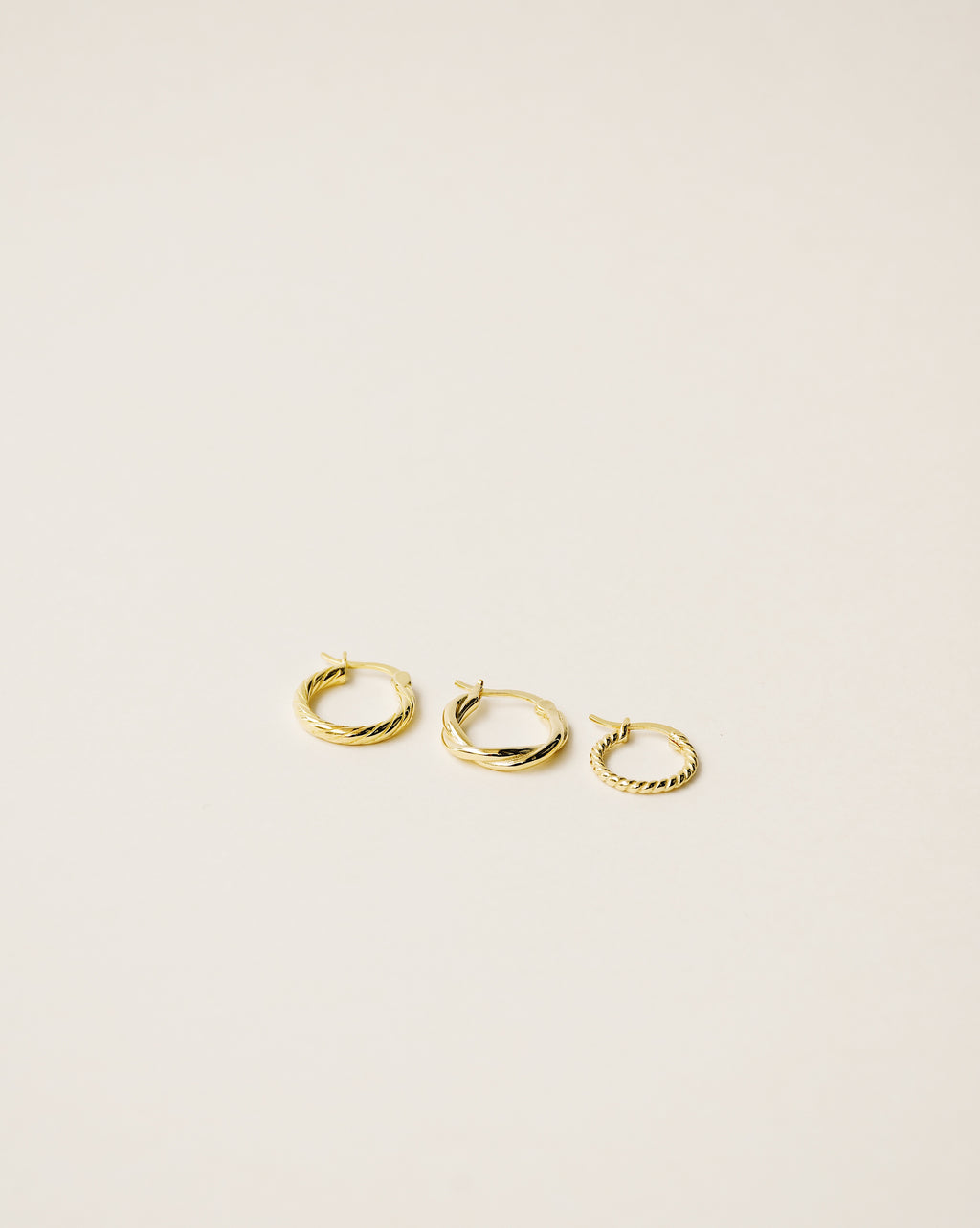 set of three different twisted hoop earrings handcrafted in 925 sterling silver plated in 18k gold. 2020 slow fashion trend.
