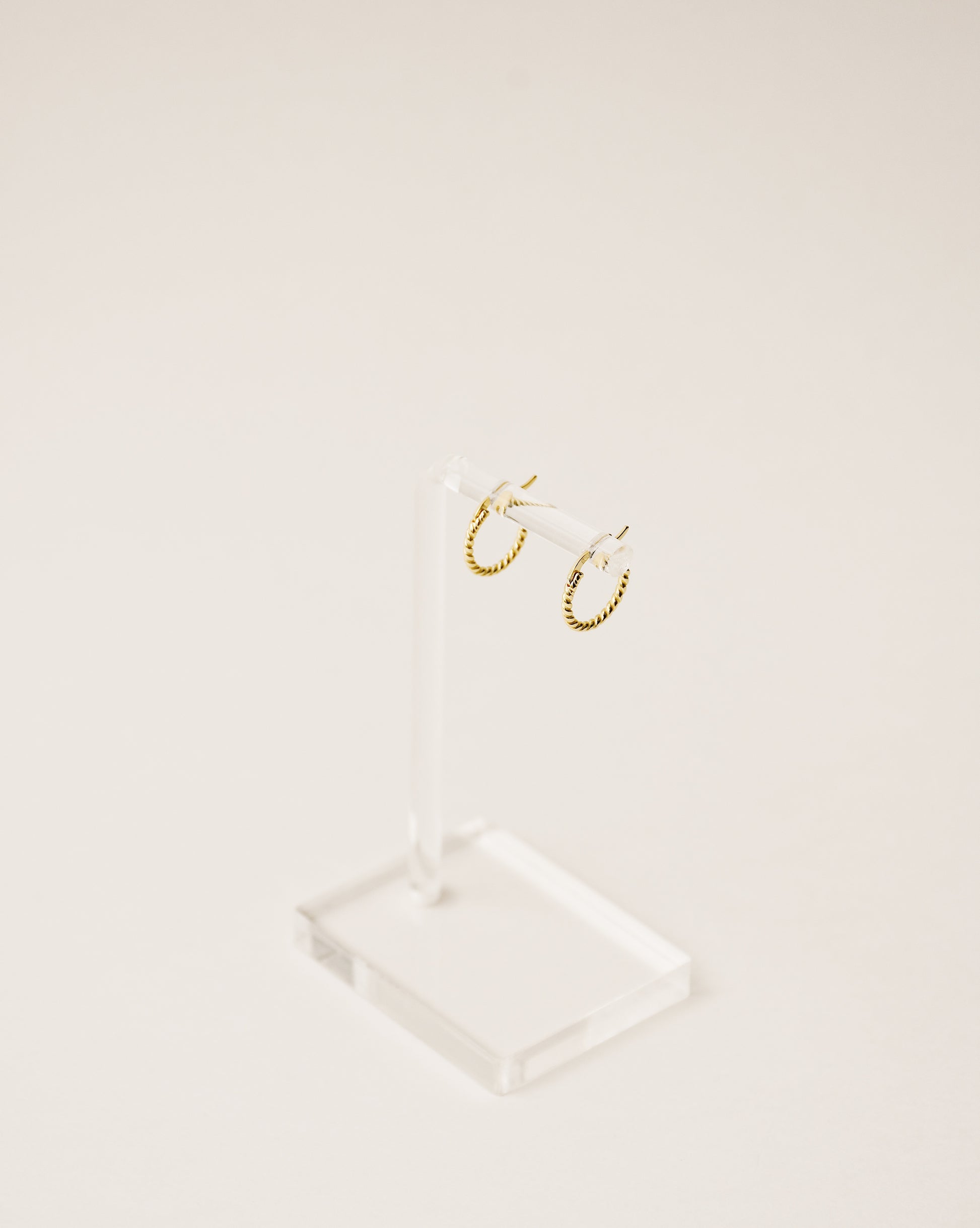timeless and versatile twisted huggie earrings handcrafted from 925 sterling silver plated in 18k gold. 2020 slow fashion trend.