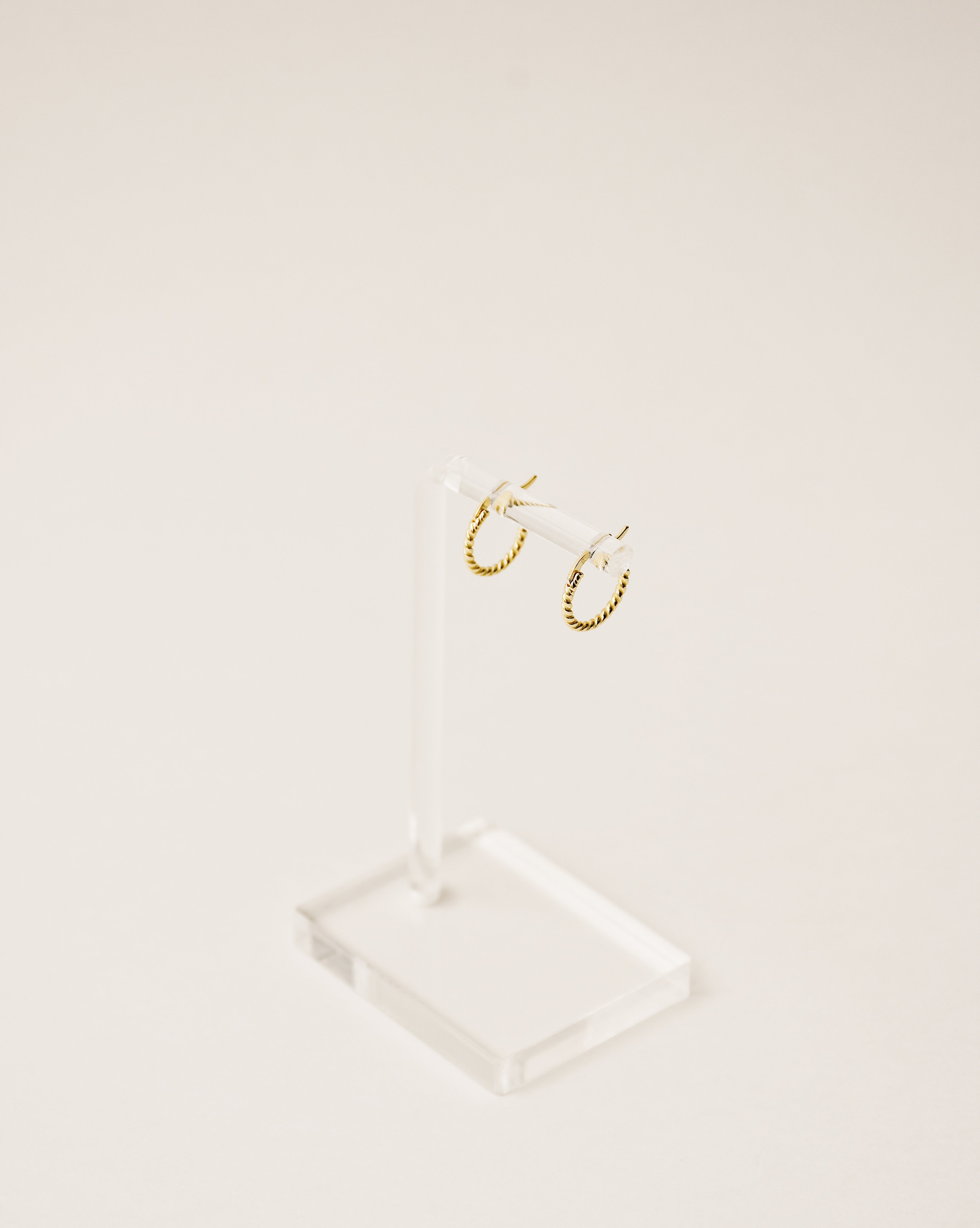 timeless and versatile twisted huggie earrings handcrafted from 925 sterling silver plated in 18k gold. 2020 slow fashion trend.