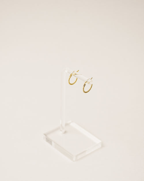 timeless and versatile twisted huggie earrings handcrafted from 925 sterling silver plated in 18k gold. 2020 slow fashion trend.