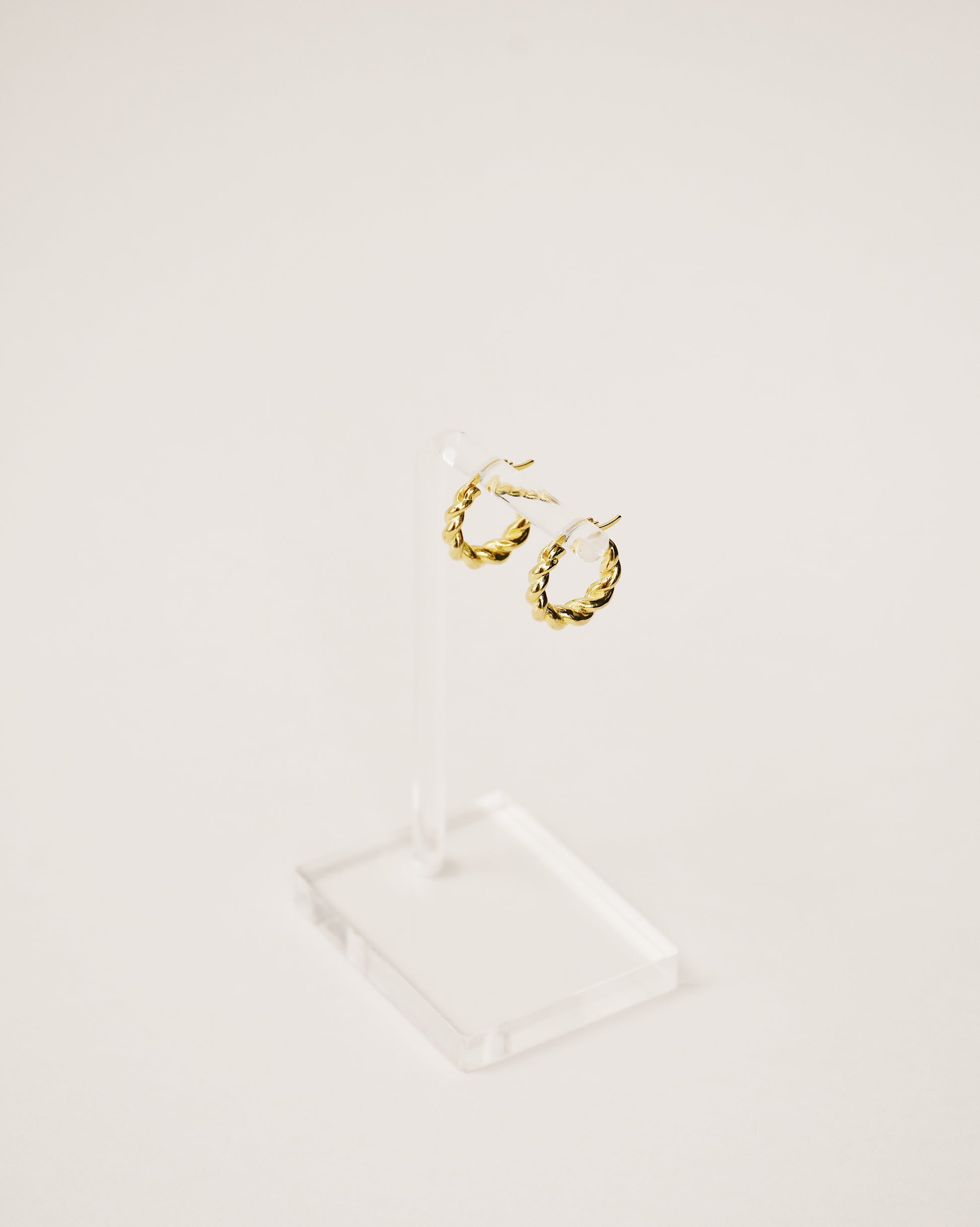 bold and modern twisted mini hoop earrings handcrafted from 925 sterling silver plated in 18k gold. 2020 slow fashion trend.